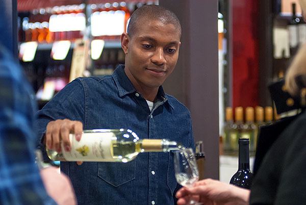 Chateau Ste. Michelle employee Alex Curry pours a sample of wine during the grand opening of Total Wine & More in Silverdale March 10.