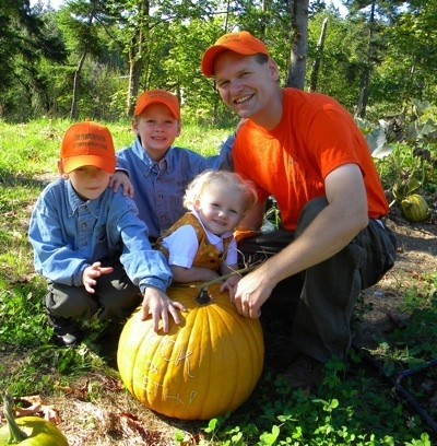 Four members of the Blossey family pose with a pumpkin grown on their new Creek House Farm.