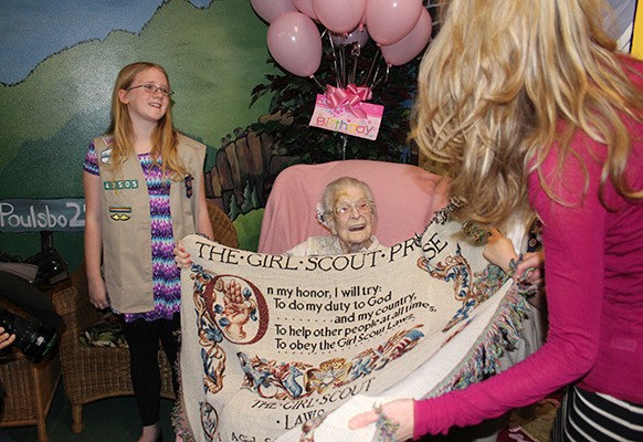 Emma Otis is presented a commemorative blanket with the Girl Scout Promise and Girl Scout Laws on it