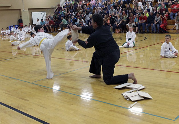 A martial arts student kicks a board during a demonstration during the Asian-Pacific Islander Heritage event at Ridgetop Junior High.