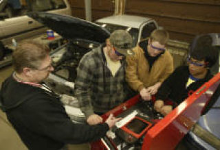 Olympic High School automotive shop instructor Rich Bennett (far left) works with students (from left) Austin Oliver