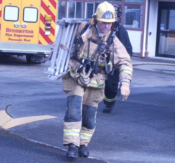 Firefighters carry a ladder during a multi-agency training drill on the Washington Veterans Home in Retsil on March 24. South Kitsap Fire and Rescue