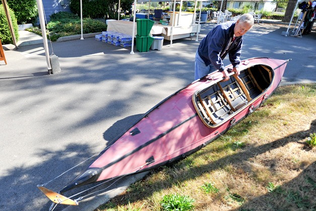Greater Hansville Community Center President Fred Nelson inspects a canoe that will be auctioned at Saturday's Rummage Sale.