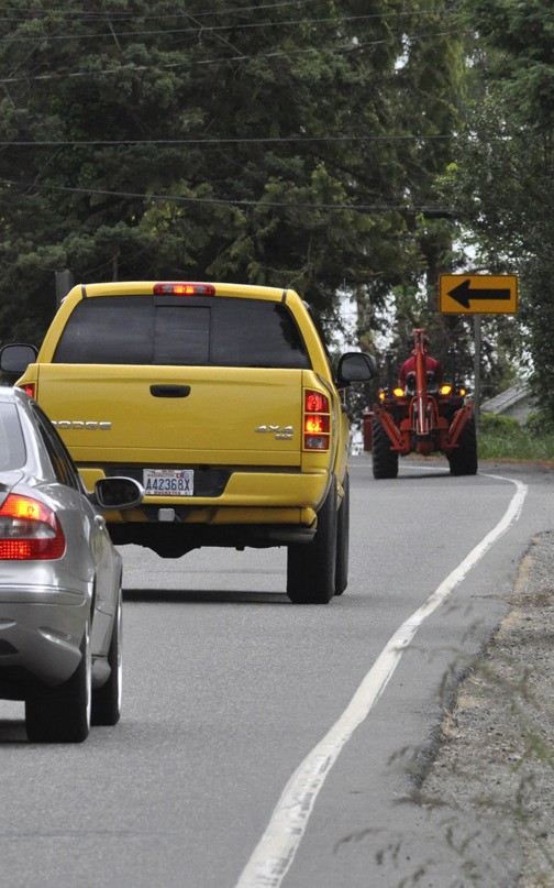 A hobby-sized tractor takes up a portion of the lane on Tracyton Blvd. NW Tuesday afternoon during drive time. The Board of County Commissioners will hear recommendations on the urban or rural lifestyles and development in the area.