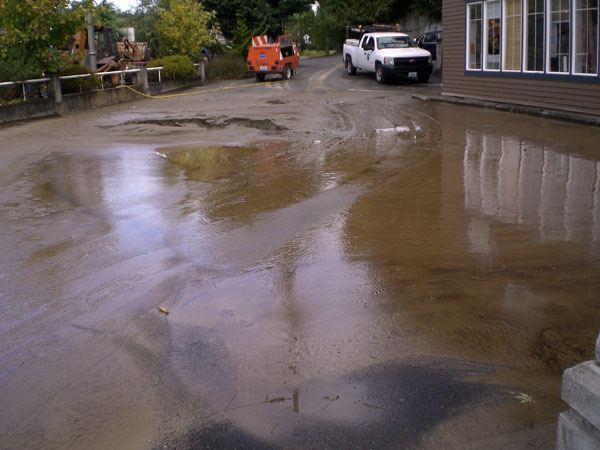 Water and sand cover the parking lot on the corner of  Bond Ave. and Front St. last Sunday