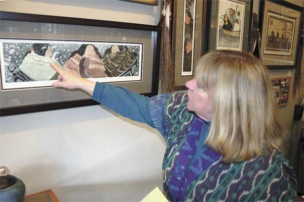 Janet Dowling explains some details of Irene Klar’s Native-themed etchings Wednesday at Potlatch Gallery. The gallery is closing after 25 years.