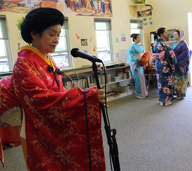 Mary Mariko Ohno adjusts her microphone as her dancers ready themselves for a performance at the downtown Bremerton Library. Ohno teaches Japanese dance