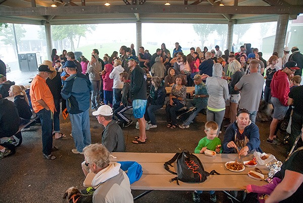 Whaling Days attendees take shelter from heavy rain.