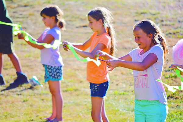 Fifth graders Mylee Miller and Lainey Eubanks cut the ribbon for Olalla Elementary School’s new grass play field.