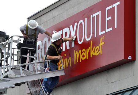 Workers from Hanson Signs Inc. put the final touches on the new Grocery Outlet sign at 9451 Silverdale Way.