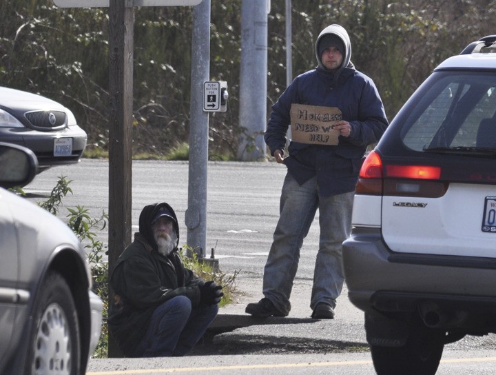 Greg Skinner/staff photo Panhandlers seek help from drivers at the southbound exist of State Highway 3 at Kitsap Way in Bremerton Feb. 28