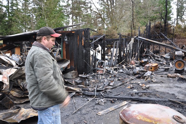 J.D. Boehme looks over the remains of a workshop and garage that was destroyed by a fire started by an orchard heater. He and his father operate the South Kitsap family business