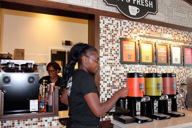 A Corner Bakery Cafe employee takes an order out to a customer on opening day.