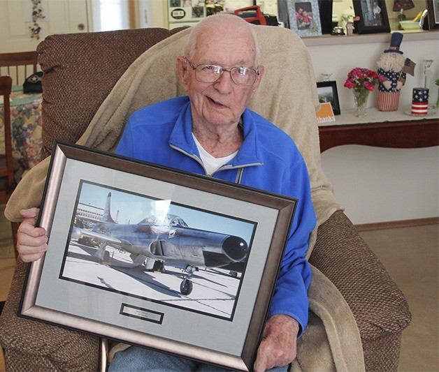Dean Ottmar of Silverdale poses with a photo of a fighter jet. Ottmar served in the Air National Guard.