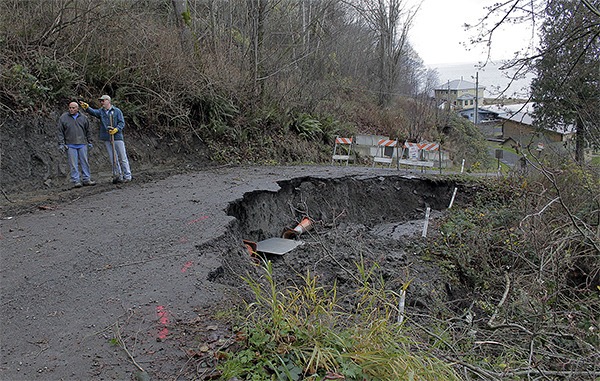 John Salinas and Gordon Becker discuss methods of fixing a section of Apple Tree Point Lane that gave way.