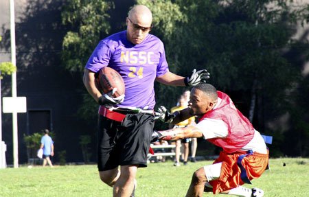 A player on the NSSC Raindevils flag football team loses his flags Tuesday. In flag football