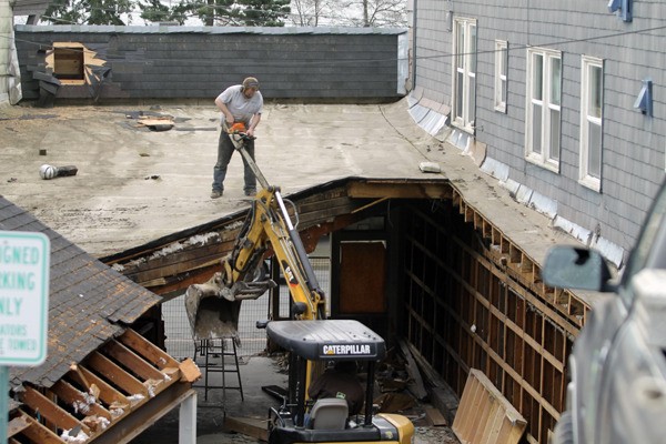 Construction workers demolish the former Voodiez Bar and Grill on Front Street