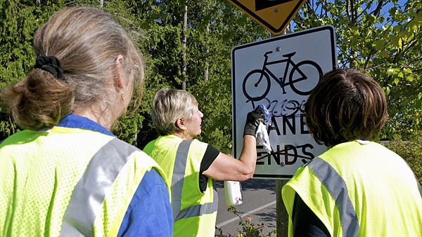 Volunteers removed graffiti from public places in Kingston Aug. 24. From left