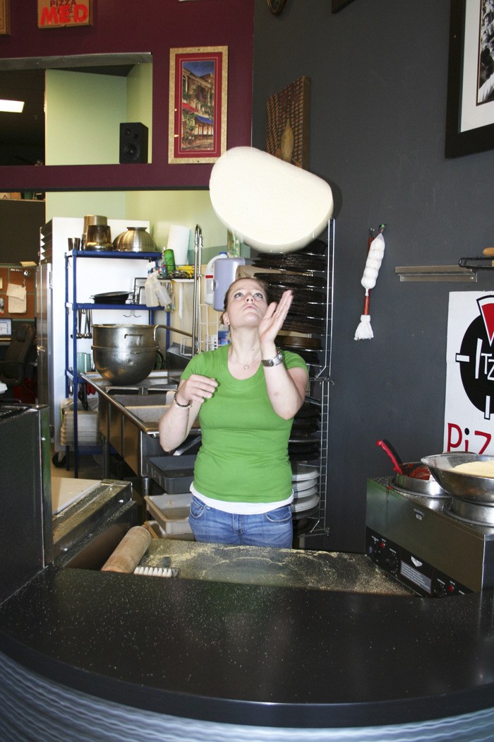 Shari Macgeorge tosses a pizza crust at her recently opened Itza Pizza Time restaurant on Lund Avenue. She wants to create an atmosphere at her establishment that is friendly to children