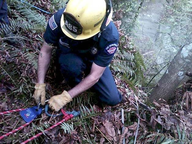 A North Kitsap Fire & Rescue firefighter checks safety gear Monday afternoon as crews prepare to assist a stranded Kingston hiker.
