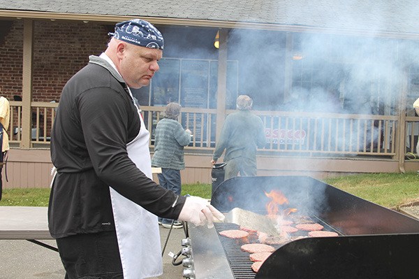 Mike O'Brien grills hamburgers and hotdogs at the kickoff of the Seabeck Conference Center Centennial year.