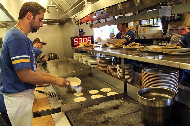 Ross McCurdy cooks up pancakes during his world record attempt in Aug. 2013 in the kitchen of The Oak Table Cafe. McCurdy holds the record for the most pancakes made in an hour.