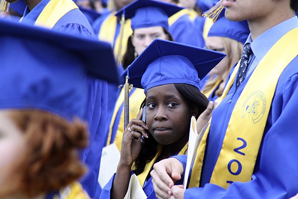 A Bremerton High School senior chats on her cell phone prior to the start of this past Friday's commencement ceremony at Memorial Stadium.