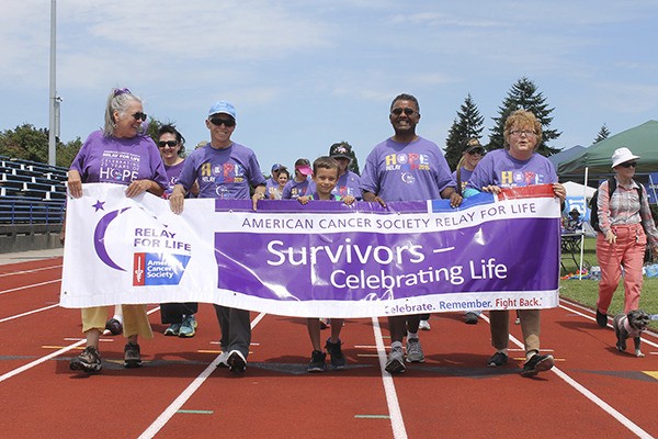 Cancer survivors clad in purple shirts make the first lap of the Relay For Life in Bremerton.