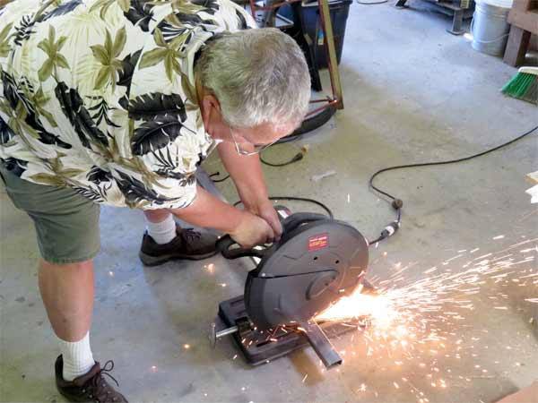Chuck Strahm cuts a piece of metal to add to the chassis of a new coaster car in his shop in Hansville