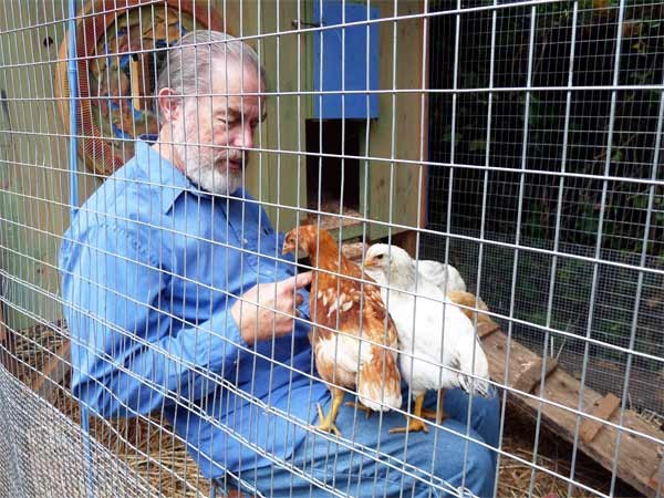 George Little with two of his chickens in his chicken coop