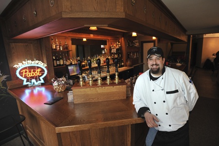 Hare and Hounds Executive Chef Chris Plourde stands with the custom bar hand-made by owner Bill Austin.