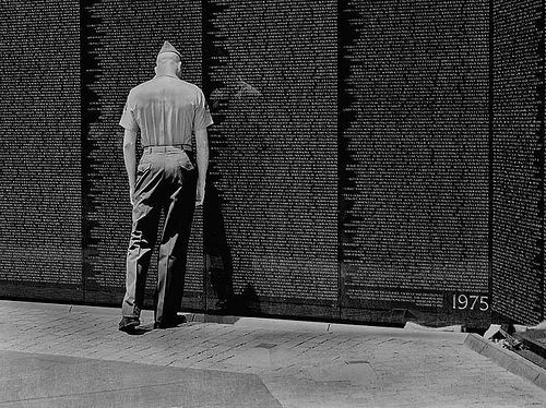 A Marine pays tribute at the Vietnam Veterans Memorial Wall in Washington