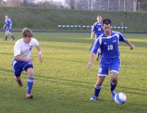 Bremerton defender Ritchie Danskin (6) closes in on Olympic’s Levi Hay in Tuesday’s 4-3 overtime loss to the Trojans.