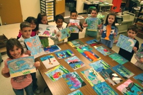 Janet Osborne’s Manchester Elementary School third-graders show off their hand-drawn art next to a table of completed quilt pieces.