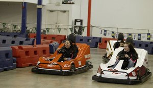 Two teenagers take a spin around the track at Kart Trax Formula Racing in Bremerton. The go-kart track is the first of its kind in the area and is popular with local children and teenagers.