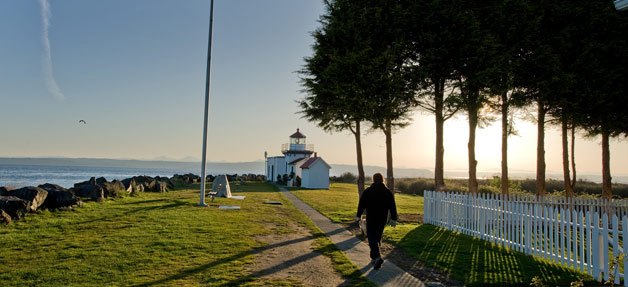 A walker strolls toward the Point No Point lighthouse on a recent morning. Below