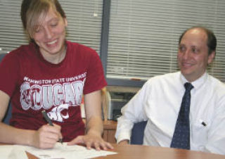 Bremerton senior Jacki Hill signs her letter of intent for Washington State University as dad Blake looks on.