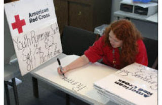 AmeriCorps volunteer Amber Rock creates signs for next Saturday’s American Red Cross rummage sale. The first-ever event will help provide funding for the youth program.