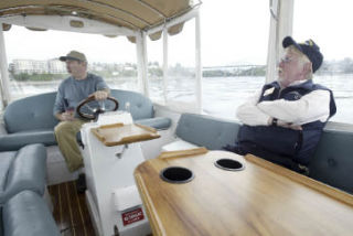 USS Turner Joy Executive Director Bill Metcalf (right) enjoys the view while riding with Northwest Boat Rentals President Bill Archer in an electric boat which can now be rented from the Turner Joy.