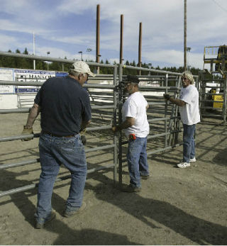 Wrangler Duffy Foutch is flanked by current Kitsap Stampede Cowpokes president John Rosebeary (left) and Cowpokes co-founder Jon Jennings during setup for this year’s Thunderbird Rodeo in June.