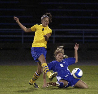 Then-Bremerton midfielder Naomi Abad tries to avoid a slide tackle by then-Olympic High forward Kayleigh (Badger) Carlson. The two are now teammates at OC.