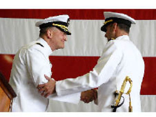 Capt. Joseph Kuzmick (left) and Capt. Brad Johanson shake hands at the recent USS John C. Stennis change-of-command ceremony.