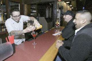 Slip 45 bartender Jorge Ayala makes a drink for  Binder Basi and Jason Walker. lounge.