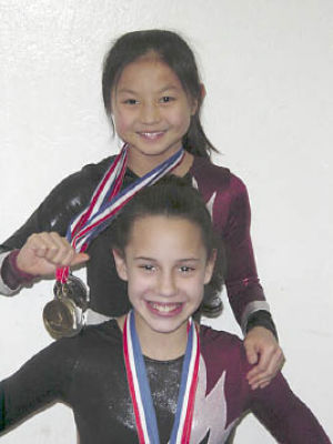 The Olympic Gymnastic Center’s Mara Ong (top) and Tara Black pose with their newest medals following the Level 7 state championships on March 29 at Auburn Mountainview High School. Black
