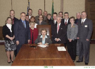Kitsap County Association of REACTORS Executive Mike Eliason and officials from the Dept. of Licensing attended a bill signing ceremony in which Gov. Chris Gregoire signed SHB2778 into law.