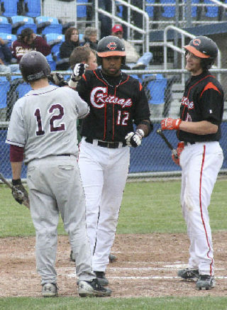 Central Kitsap senior Caleb Brown is congratulated by fellow Cougar Dan Zylstra (right) and South Kitsap’s Todd Dalrymple after hitting his second homer of the day Thursday.
