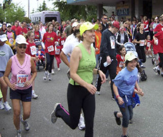 Courtesy photo Runners wear wide grins as they cross the finish line on June 1 at the Kitsap Family Fun Run. Ridgetop Junior High School’s Jessica Sanchez won the girls’ 1-mile run while Olympic High’s John Wojtech won the boys race.  Fellow Trojan Brendan Schruhl took first in the 5K event