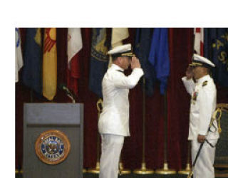 Capt. Mark J. Olson (left) salutes outgoing Naval Base Kitsap Capt. Reid S. Tanaka at the change of command ceremony Wednesday.