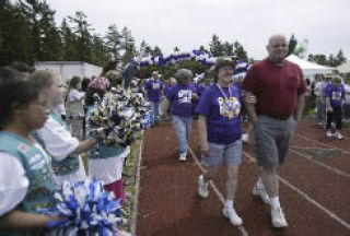 Girls Scouts from Troop 50599 of Bremerton wave pom-poms during the survivors lap at Relay for Life of Central Kitsap & Bremerton at the Central Kitsap High School track June 21.