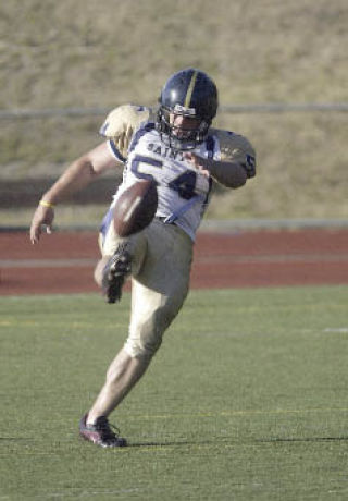 Saints special teams standout and defender Josh Burlingame punts the ball against Southern Oregon to open the season.